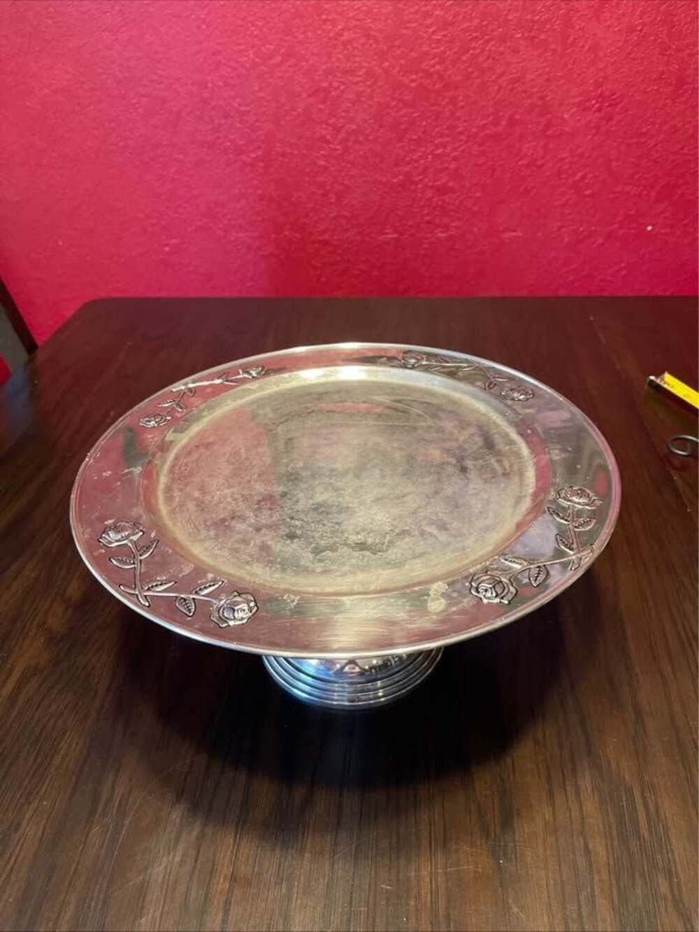 Vintage silver-plated pedestal cake stand featuring an embossed rose and stem de
